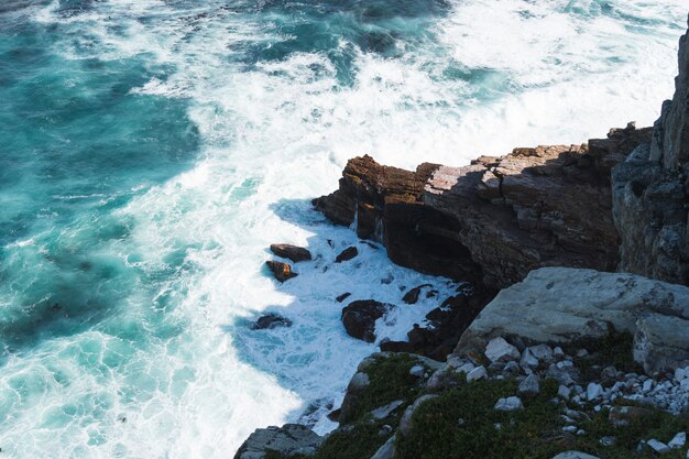 Colpo di alto angolo di una formazione rocciosa vicino al corpo di acqua turchese