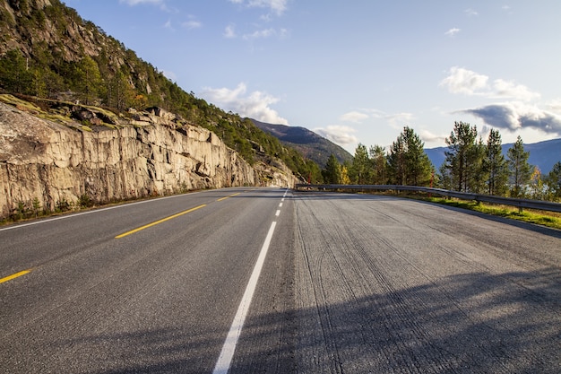 Colpo di alto angolo di una strada vuota in Norvegia, circondata da alberi e colline