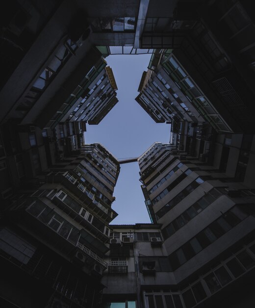 Colpo di angolo basso delle costruzioni di appartamento alte sotto il cielo scuro