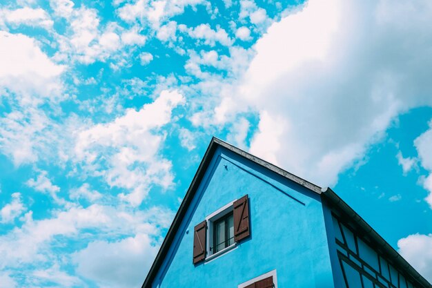 Colpo di angolo basso di un fabbricato agricolo blu che tocca il cielo nuvoloso