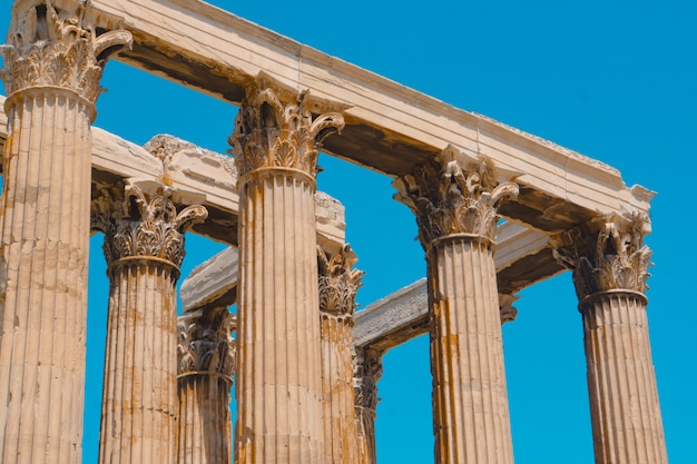 Colpo di angolo basso di vecchie colonne di pietra greche con un chiaro cielo blu