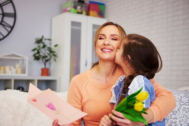 Colpo di bambino che bacia la sua mamma sulla guancia che