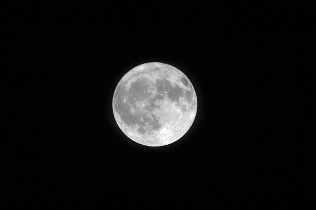 Colpo di paesaggio di una luna piena bianca con colore nero sullo sfondo
