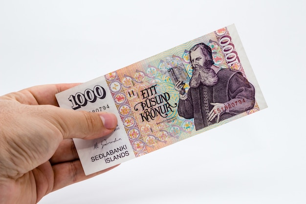 Colpo di primo piano alto angolo di una persona in possesso di una banconota su uno sfondo bianco