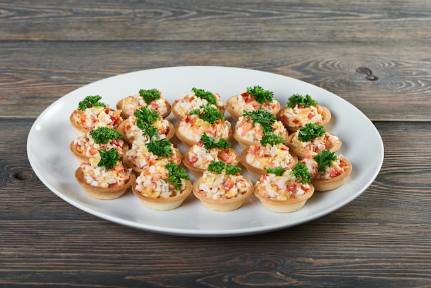 Colpo di un piatto con tortine con insalata decorata con verdure sul tavolo in legno antipasto gourmet soggiorno di lusso menu del ristorante ordine cibo delizioso gustoso mangiare.