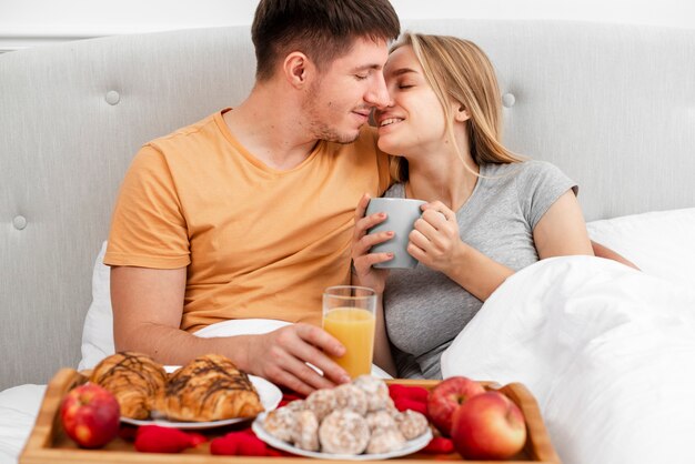Colpo felice coppia felice con colazione e succo di frutta