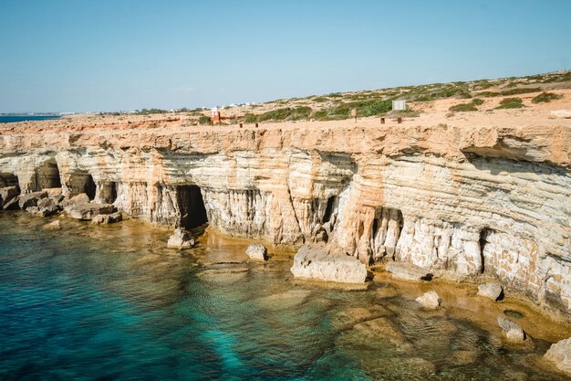 Colpo grandangolare delle grotte marine a Cipro durante il giorno