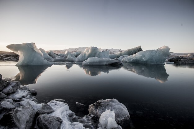 Colpo in scala di grigi degli iceberg vicino all'acqua congelata nel nevoso Jokulsarlon, Islanda