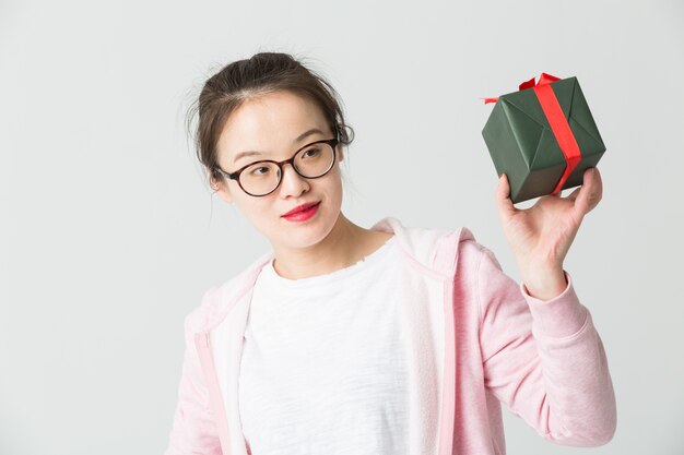 Colpo in studio della giovane donna asiatica con un regalo di Natale