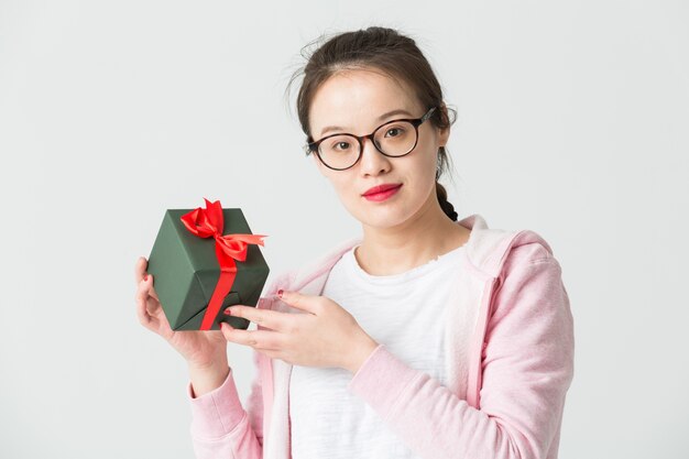 Colpo in studio della giovane donna asiatica con un regalo di Natale