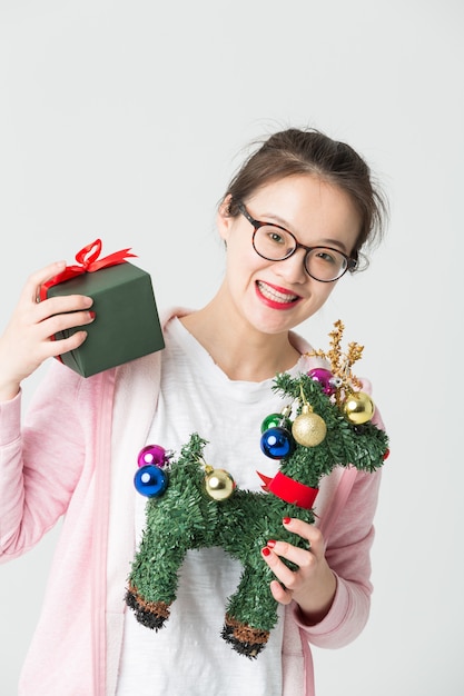 Colpo in studio della giovane donna asiatica con un regalo di Natale