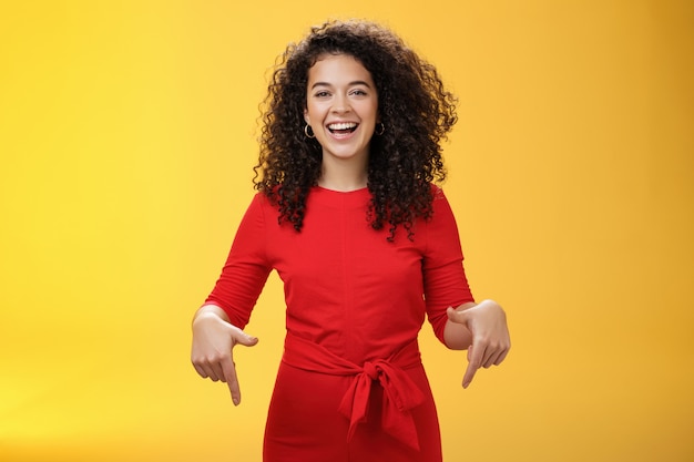 Colpo in vita di giovane donna affascinante e felice assertiva con l'acconciatura riccia che ride gioiosamente sorridendo...