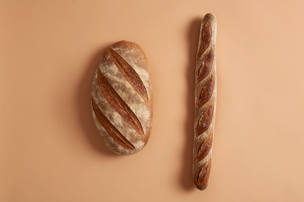 Colpo isolato di pagnotta di pane e baguette a base di farina biologica, a base di lievito. Panetteria tradizionale francese. Vista dall'alto. Prodotti da forno freschi fatti in casa senza glutine. Vari tipi, varietà di cibo