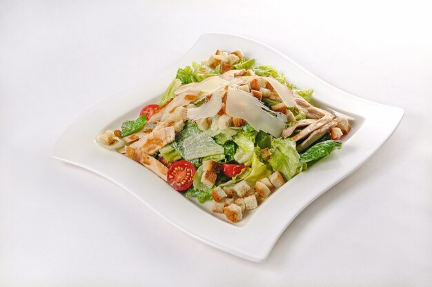 Colpo isolato di un piatto bianco con insalata Caesar - perfetto per un blog di cibo o l'utilizzo di menu