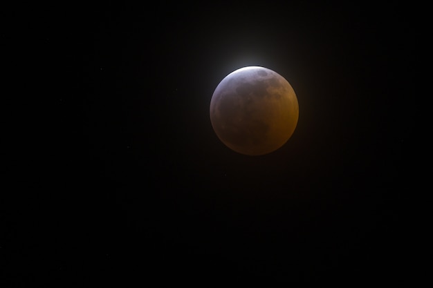 Colpo largo del primo piano di una luna piena su una priorità bassa nera