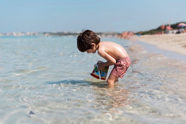 Colpo laterale di un bambino che gioca in acqua