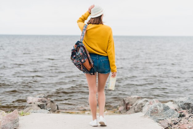 Colpo lungo del viaggiatore di fronte al mare