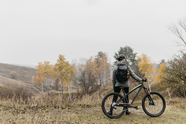 Colpo lungo dell'uomo che guida una bicicletta