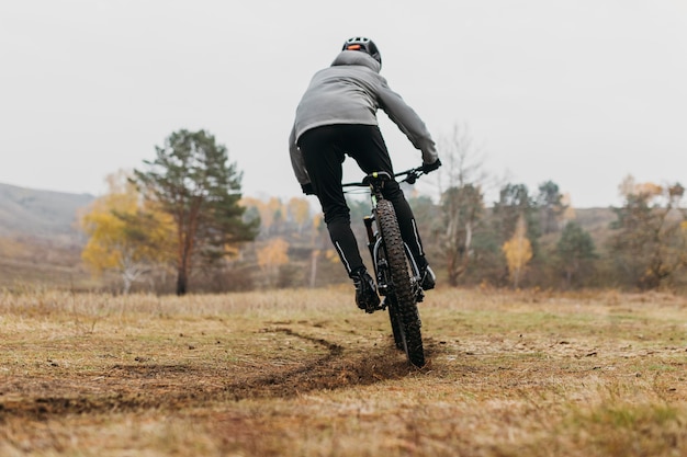 Colpo lungo dell'uomo che guida una bicicletta