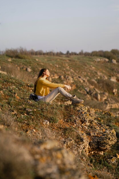 Colpo lungo di giovane donna che gode della natura intorno a lei