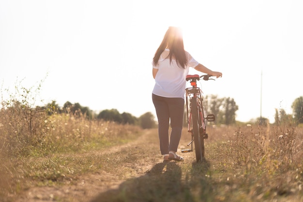 Colpo lungo di un giovane e una bicicletta