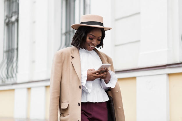 Colpo medio bella donna che osserva sul suo telefono