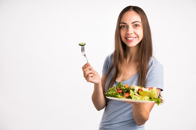 Colpo medio della donna che tiene un'insalata