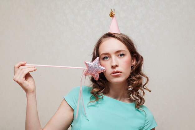 Colpo medio della donna con cappello da festa e stella