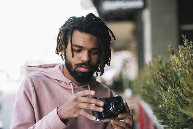 Colpo medio della macchina fotografica bella della tenuta dell'uomo