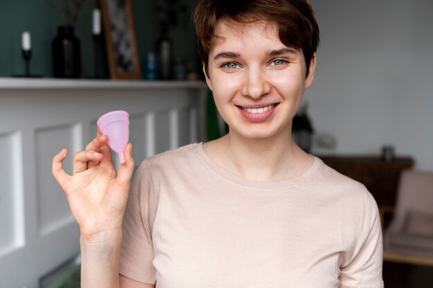 Colpo medio della tazza mestruale della tenuta della donna