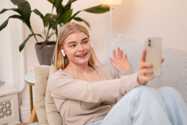 Colpo medio dello smartphone della tenuta della donna