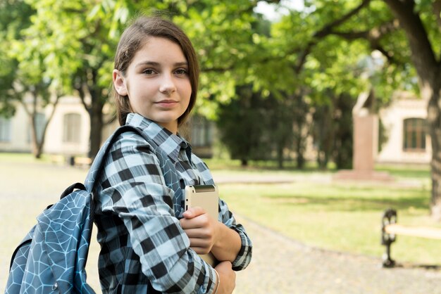 Colpo medio di vista laterale della compressa sicura della tenuta della ragazza della scuola