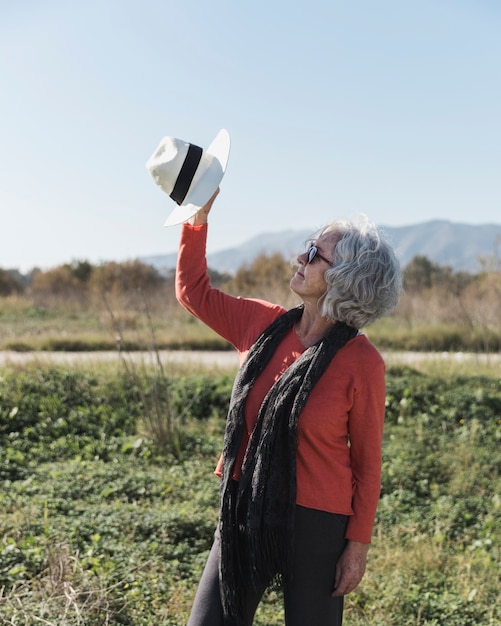 Colpo medio donna alzando un cappello