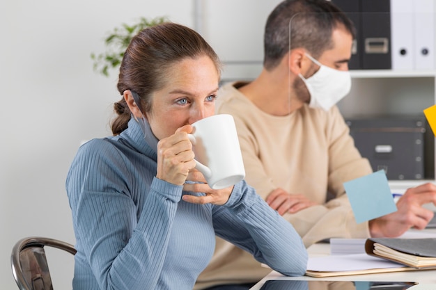 Colpo medio donna che beve caffè