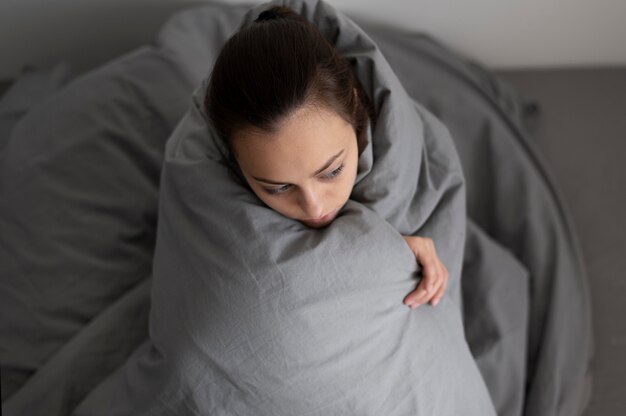 Colpo medio donna che copre con una coperta