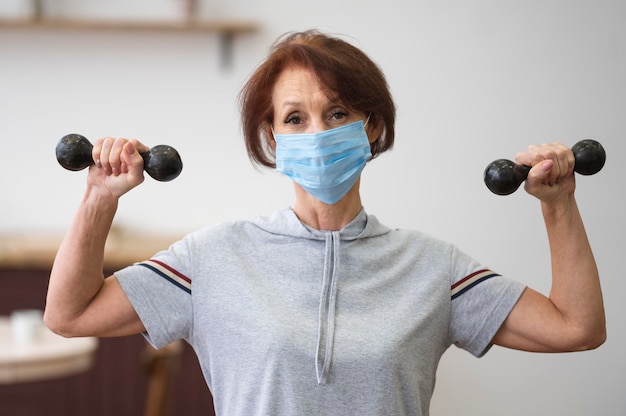 Colpo medio donna che indossa maschera medica