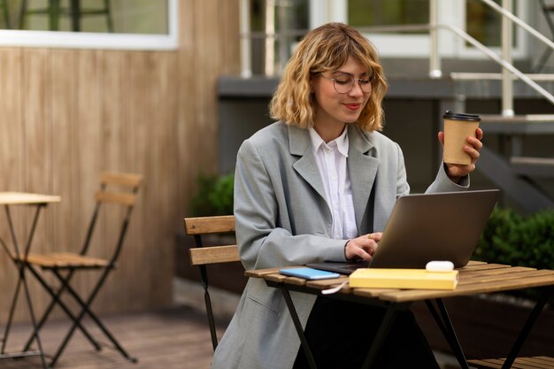 Colpo medio donna che lavora al computer portatile