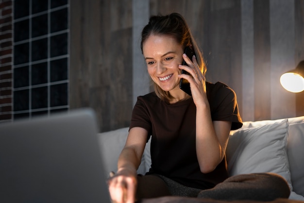 Colpo medio donna che lavora al computer portatile