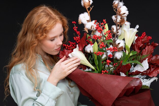 Colpo medio donna che odora di fiori