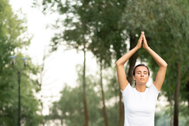 Colpo medio donna con gli occhi chiusi meditando