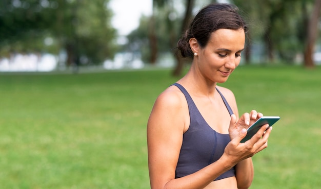 Colpo medio donna con smartphone