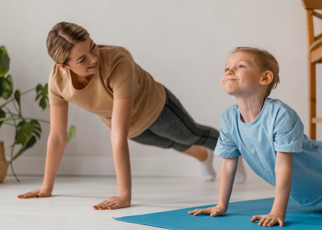 Colpo medio donna e bambino che si esercitano