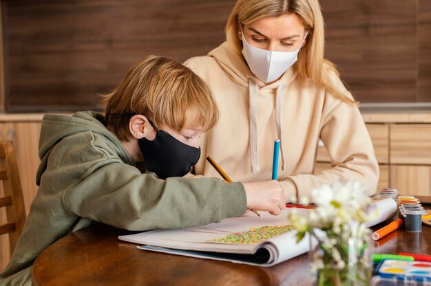 Colpo medio donna e bambino con maschera