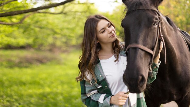 Colpo medio donna e cavallo all'aperto