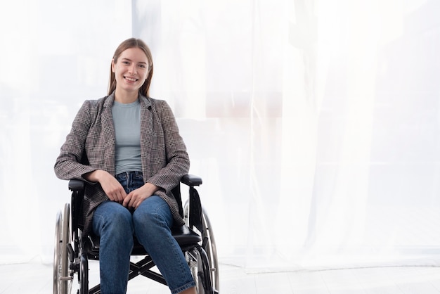 Colpo medio donna felice in sedia a rotelle