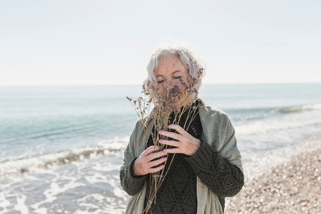 Colpo medio donna in riva al mare con fiori