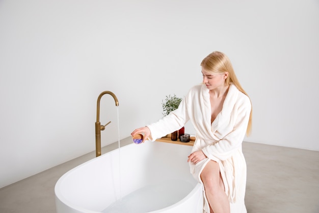 Colpo medio donna seduta sulla vasca da bagno