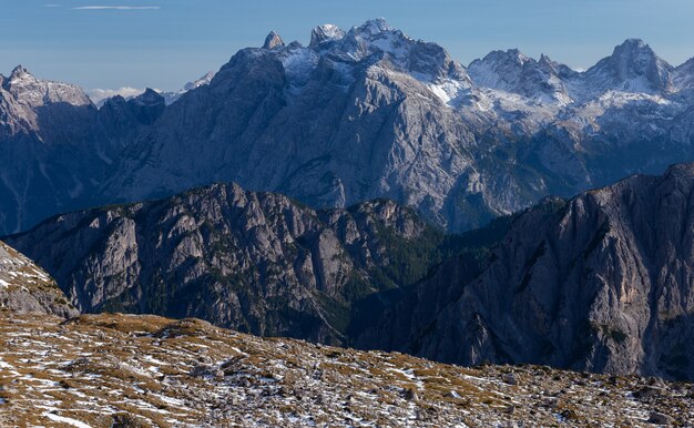 Colpo mozzafiato di rocce innevate nelle Alpi italiane sotto il cielo luminoso