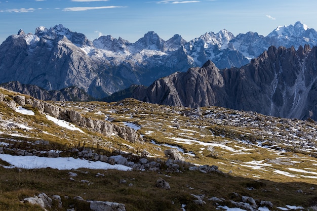 Colpo mozzafiato di rocce innevate nelle Alpi italiane sotto il cielo luminoso