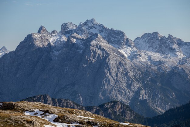 Colpo mozzafiato di rocce innevate nelle Alpi italiane sotto il cielo luminoso